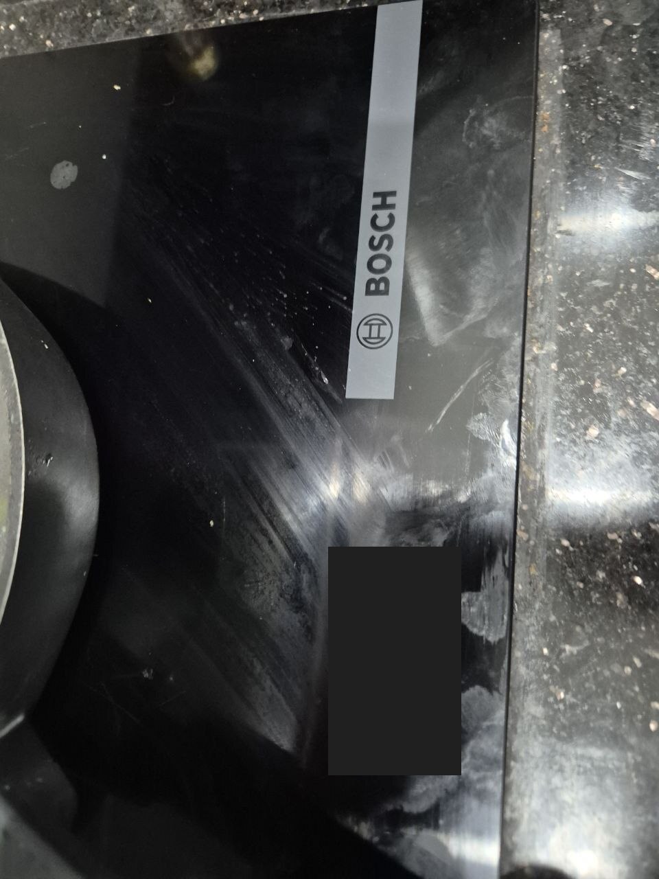 Mặt kính bếp từ Bosch với logo và nhãn thông tin đã che
